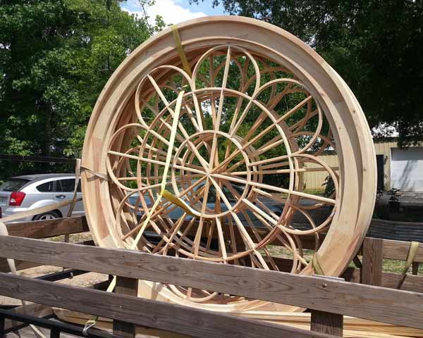 7 foot diameter round wooden window frames, loaded on a trailer for delivery.  