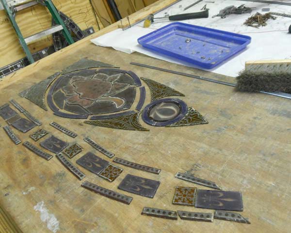pieces of a stained glass window laid on a worktable to be re-leaded