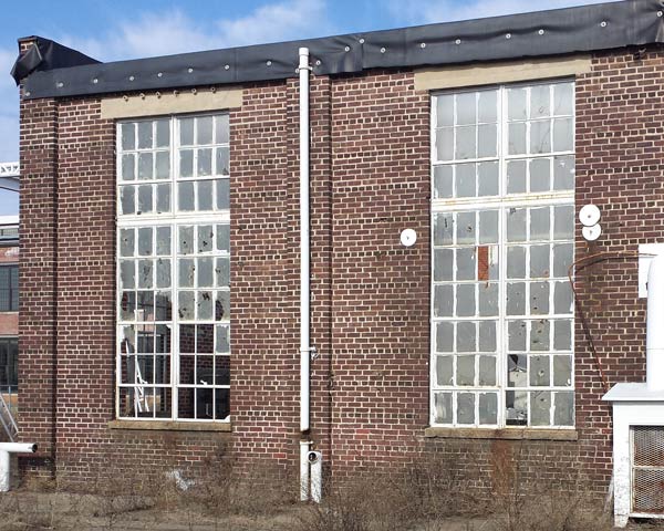 Exterior of building - yellowed plastic-looking material coats the stained glass windows so their design is barely visible